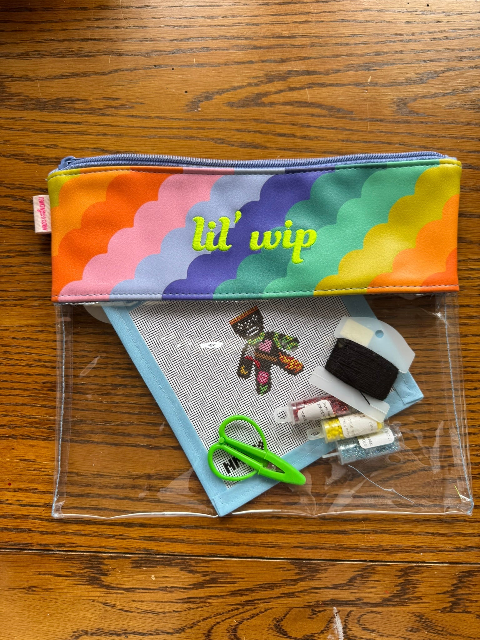 Colorful project bag with needlepoint canvas and accessories
