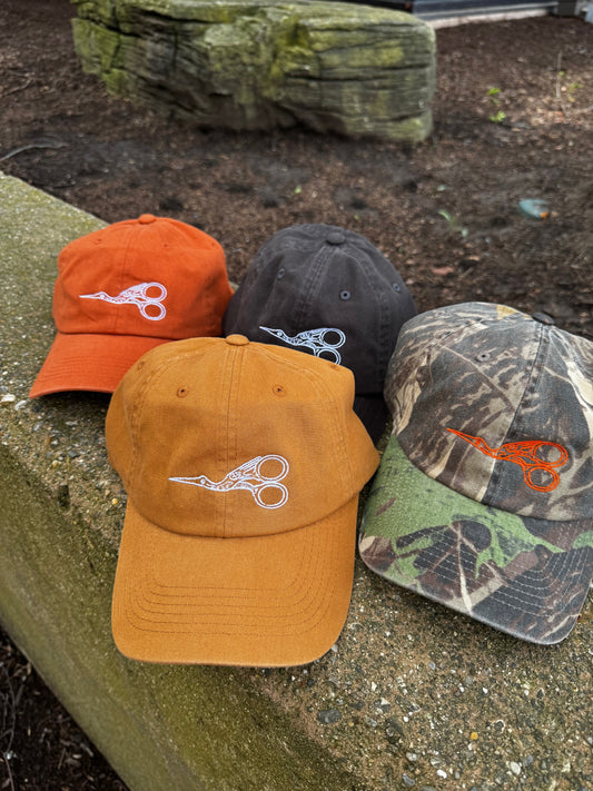 Four baseball caps with the same design on a stone surface